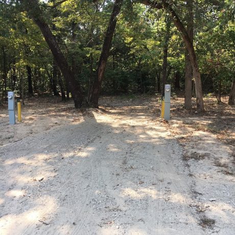 An image showcasing RV sites nestled among lush, manicured oak trees, highlighting the serene and shaded environment for a relaxing stay at Lavender Place & RV.